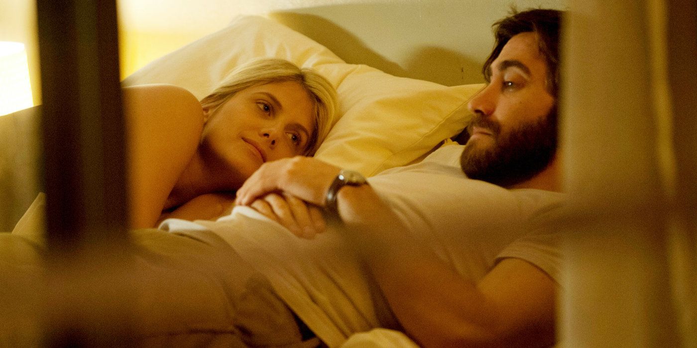 Jake Gyllenhaal as Anthony and Melanie Laurent as Mary in Enemy lying in bed. 
