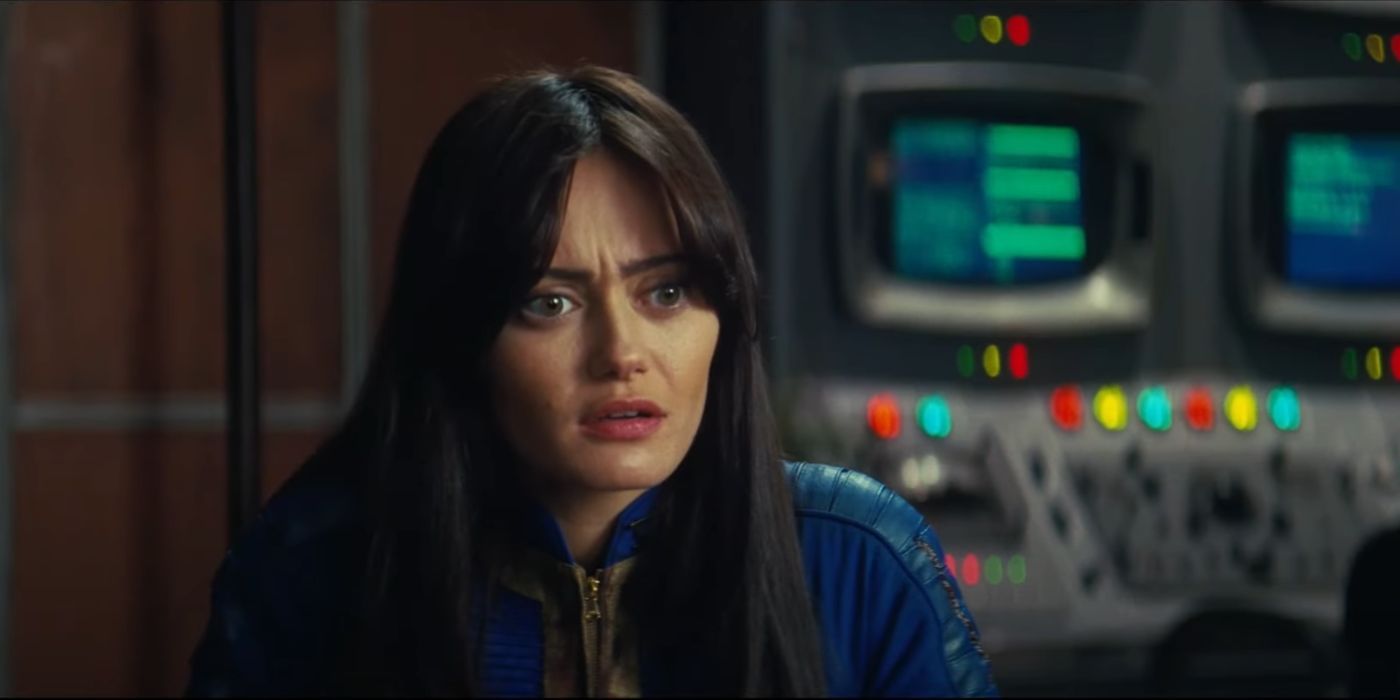 Ella Purnell as Lucy looking confused in Fallout with a glowing control panel behind her