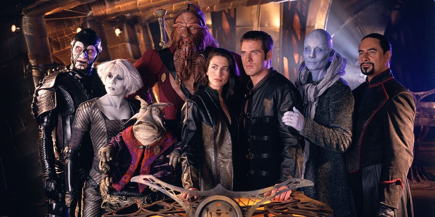 A Farscape Season 2 cast photo of Scorpius, Chiana, Rygel, D'Argo, Aeryn Sun, John Crichton, Zhaan, and Crais standing close together on Moya's bridge