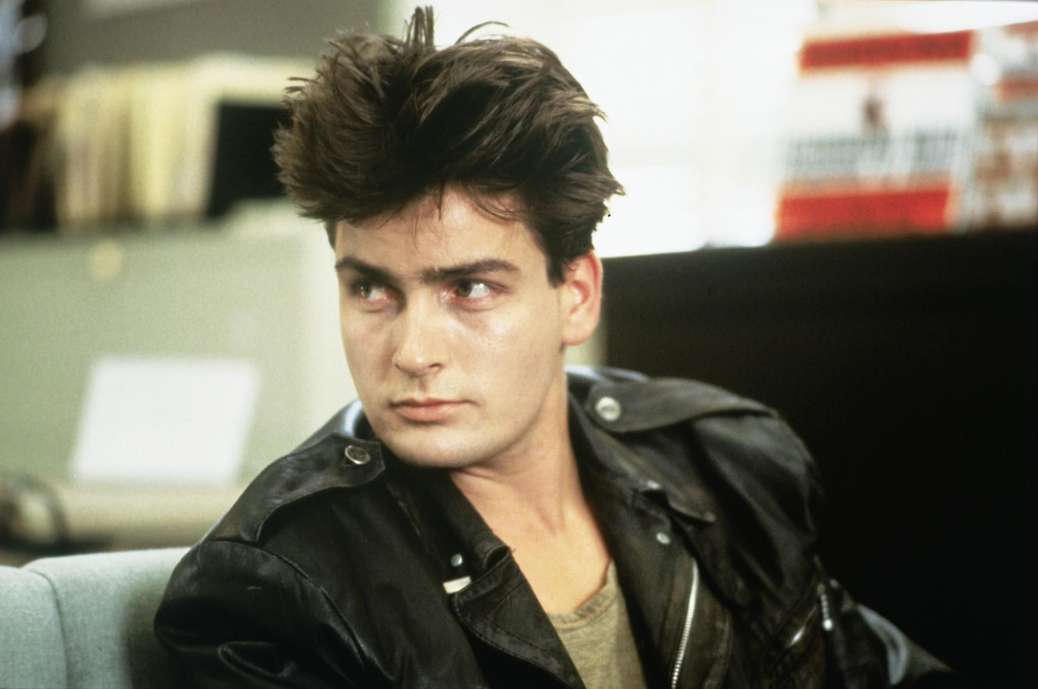 Charlie Sheen as Garth sitting in the police station in Ferris Bueller's Day Off