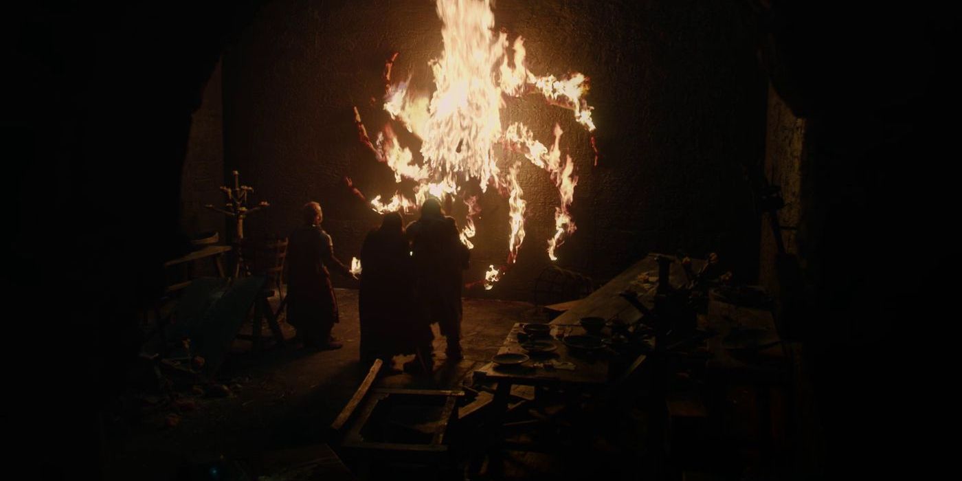 Three figures stand in front of an ancient, firey symbol in Game of Thrones