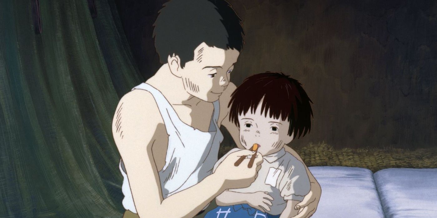 Seita tenderly feeding a weakened Setsuko in Grave of the Fireflies