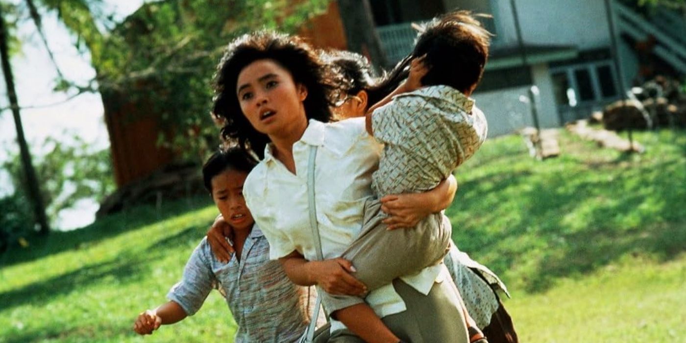 Hiep Thi Le as Le Ly Hayslip, running and looking scared with a child in her arms in Heaven & Earth (1993)