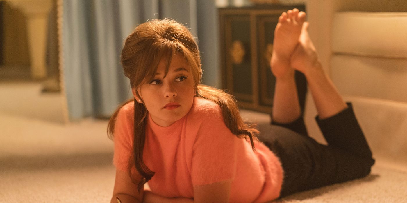 Priscilla Presley (Cailee Spaeny) lying on the carpet with her barefeet in Priscilla