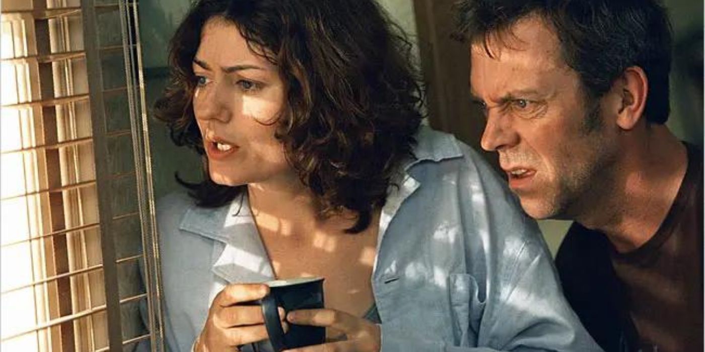 Hugh Laurie and Anna Chancellor as Paul and Estelle Slippery looking through the blinds out the window in the sitcom 'Fortysomething'