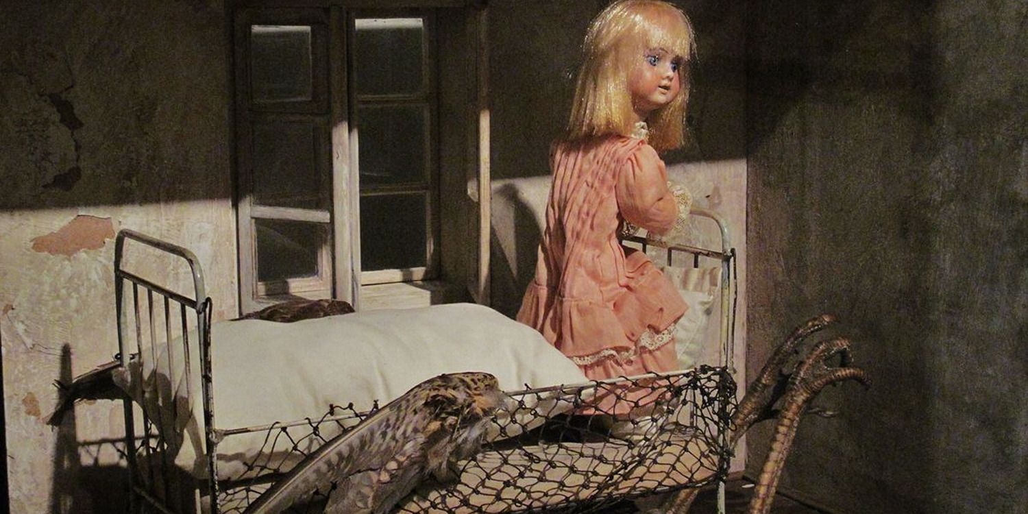 A doll kneeling on a bed next to a window in the movie Alice