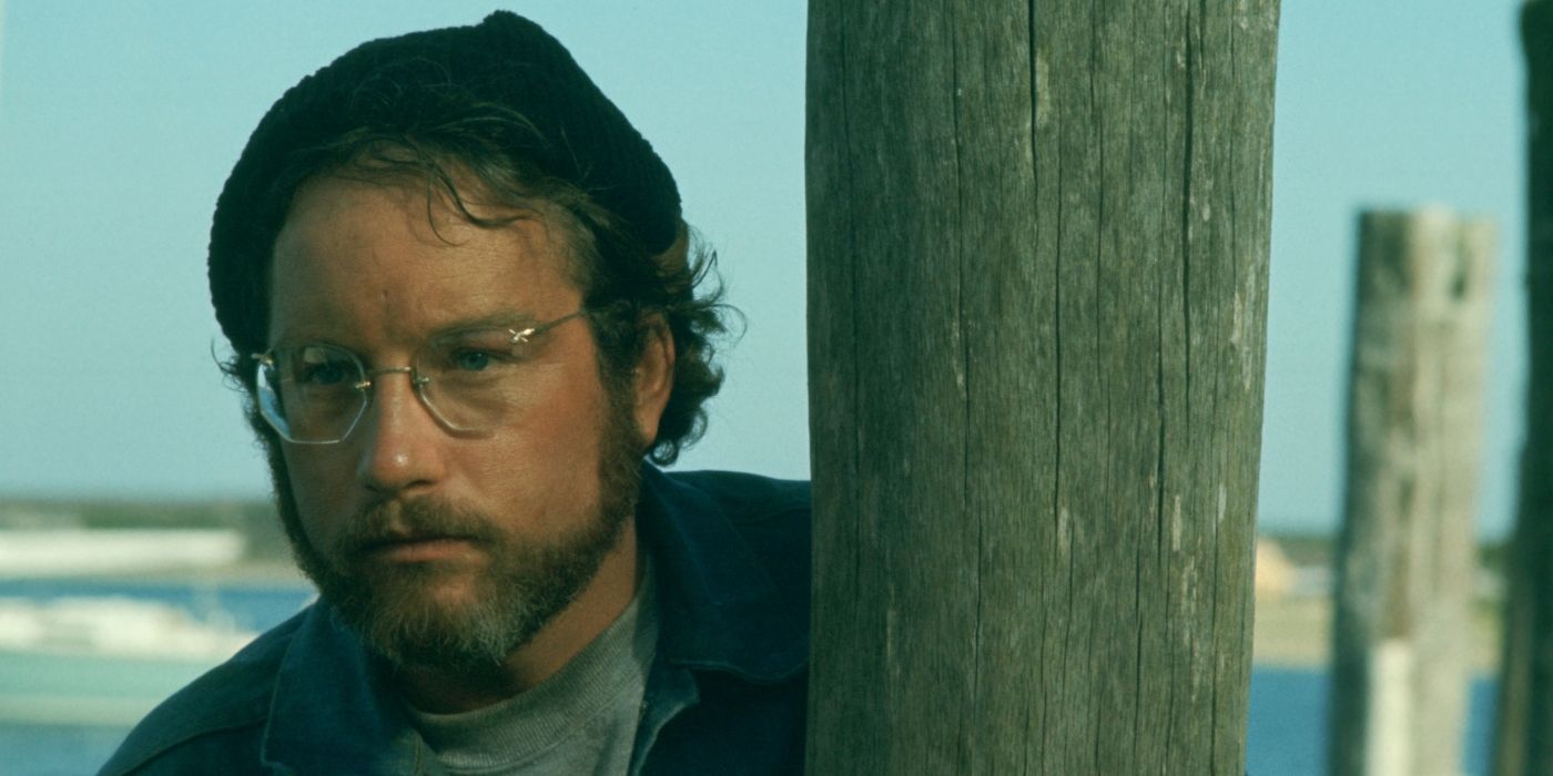 Richard Dreyfuss as Matt Hooper peeking round a wooden pillar in Jaws (1975)