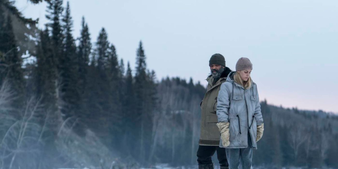 Jeffrey Wright and Riley Keough as Russell and Medora standing in the snow on a poster for Hold the Dark