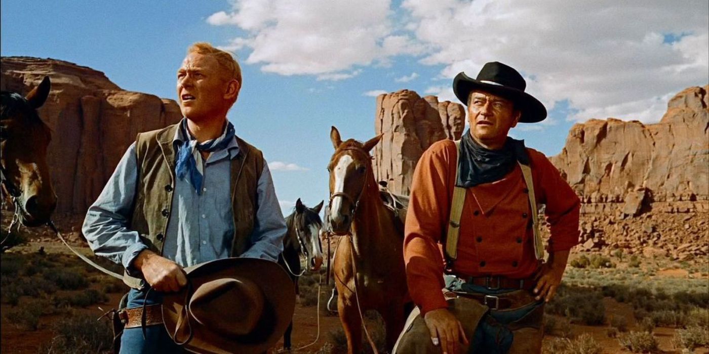 John Wayne and Harry Carey Jr. standing in the wild frontier in The Searchers