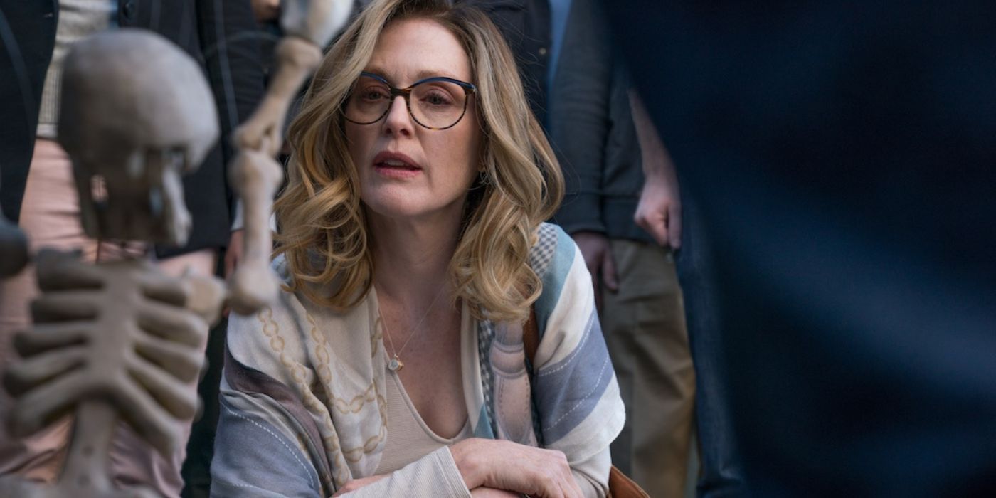 Julianne Moore as Gloria Bell crouching and looking at a skeleton in Gloria Bell.