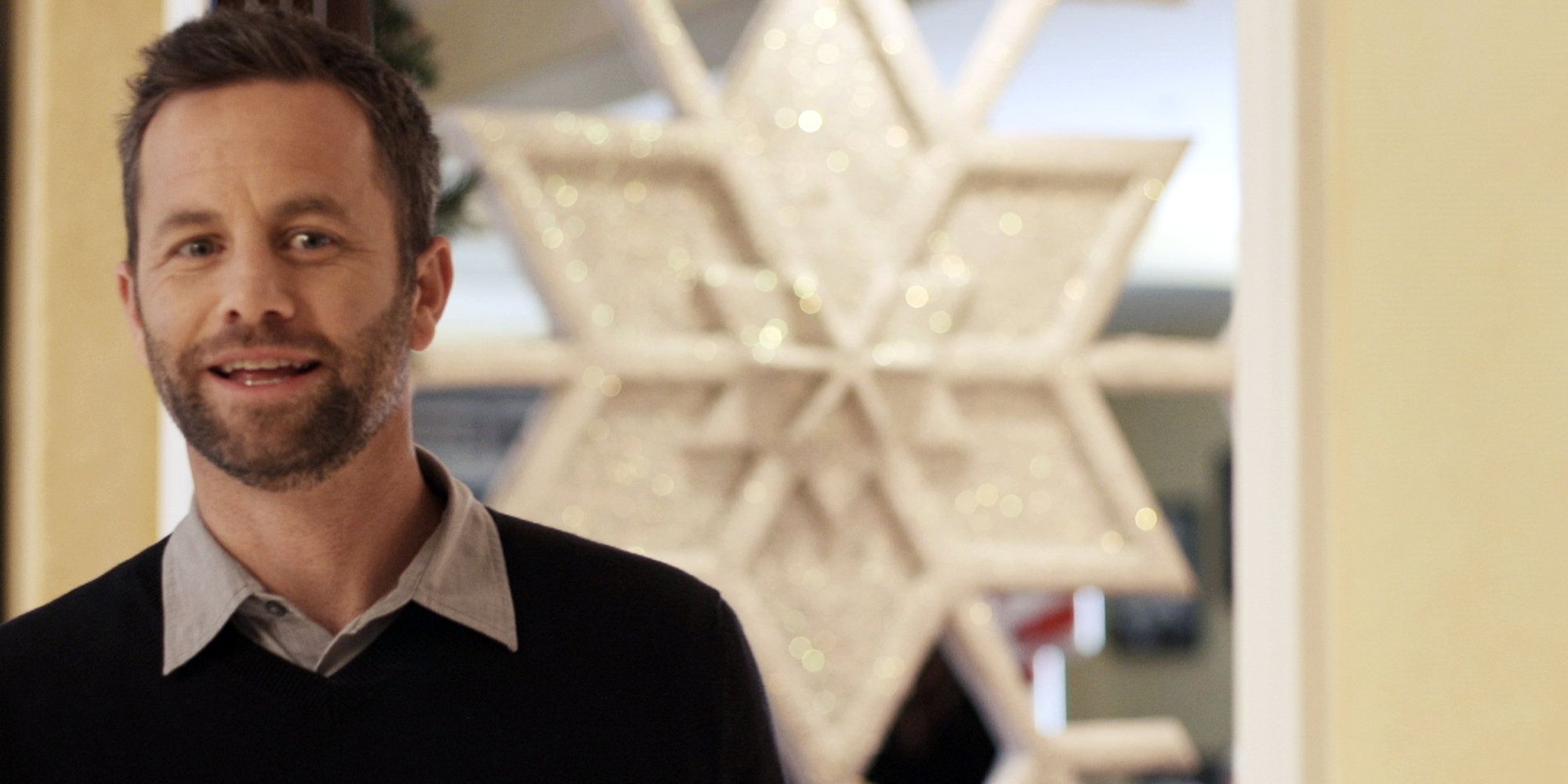 Kirk Cameron talking in front of a giant snowflake in Saving Christmas