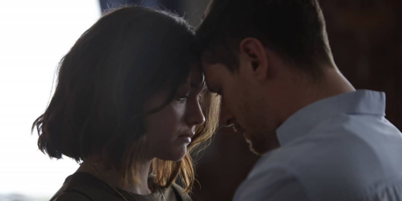 Olivia Cooke and Jack O'Connell lightly pressing their foreheads together in Little Fish