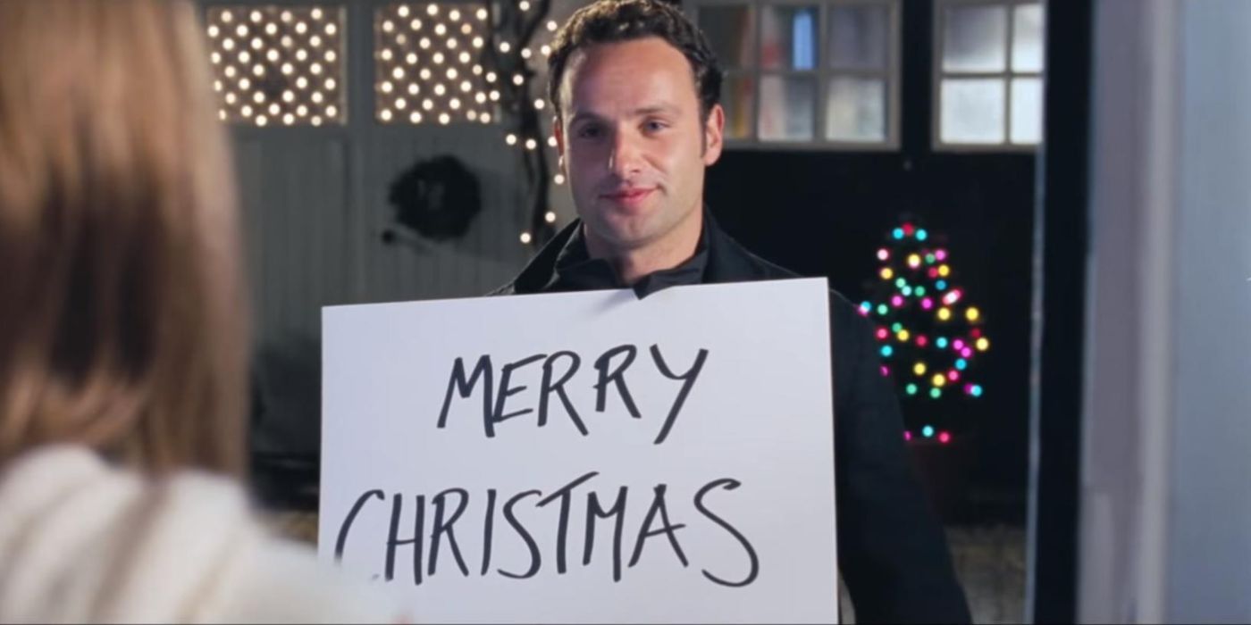 Andrew Lincoln in Love Actually holding a sign that says Merry Christmas