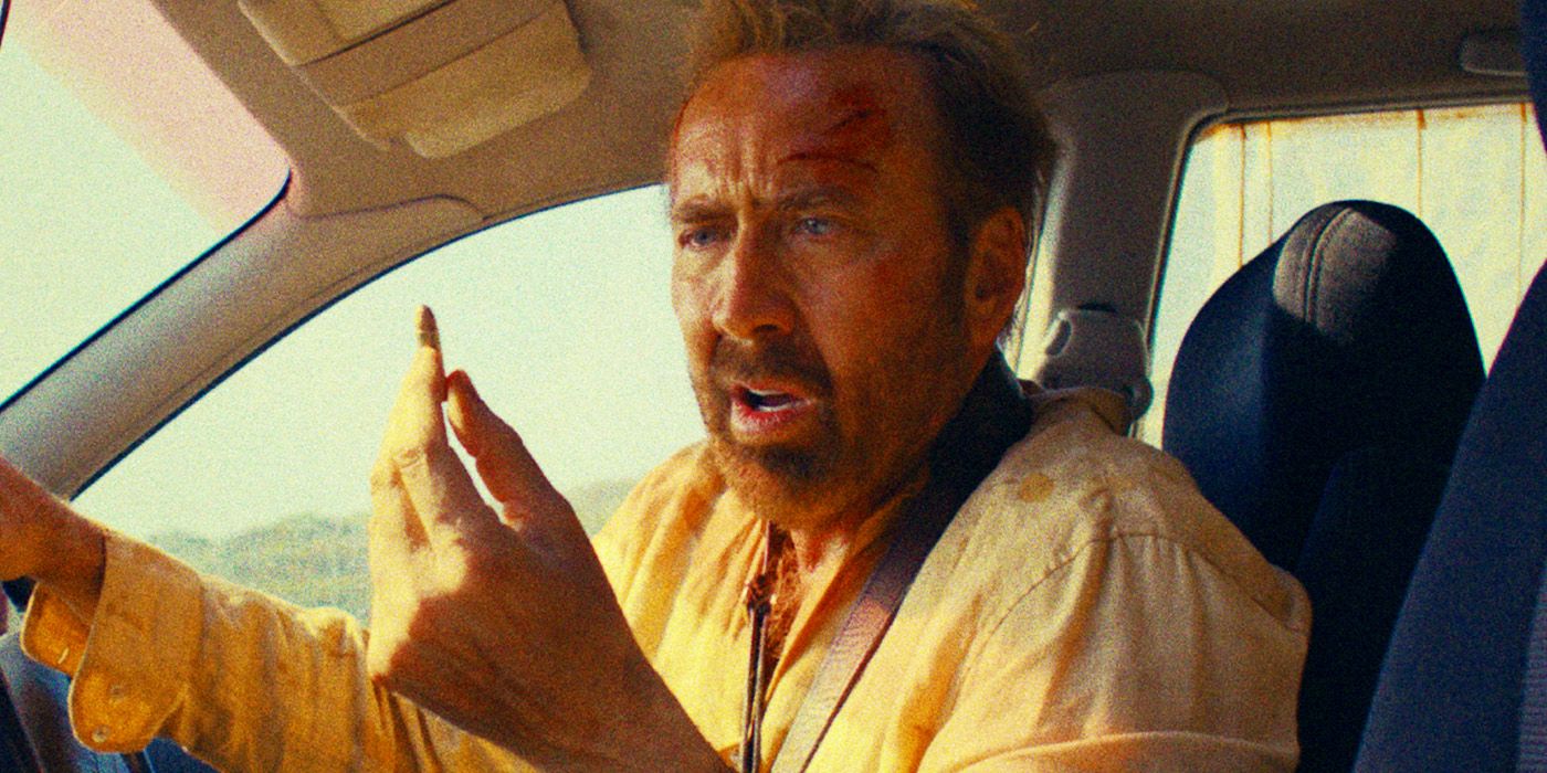 Nicolas Cage holding a bullet while sitting in the drivers seat of a car in The Surfer