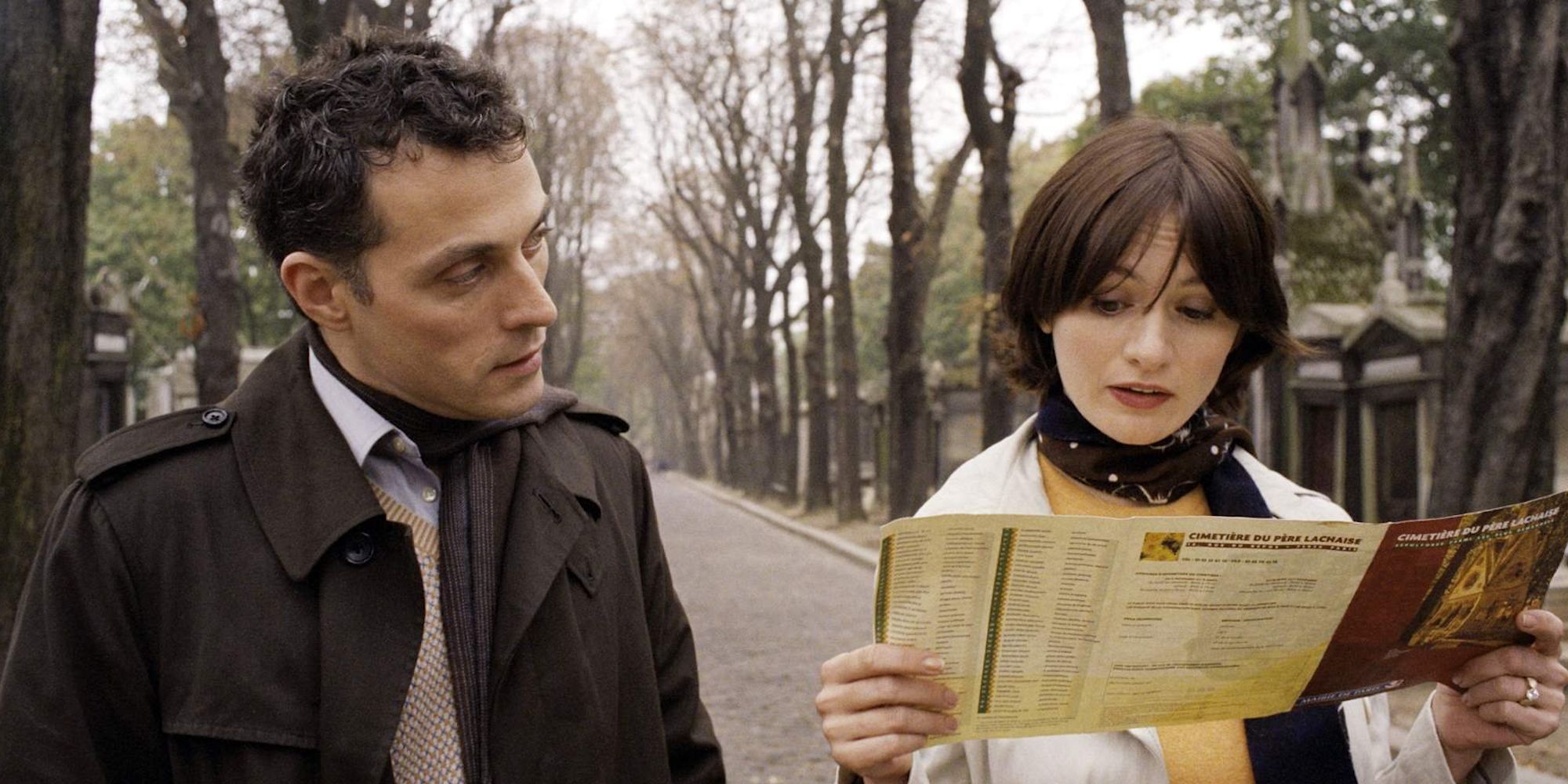 A man and woman reading a booklet outside in Paris, je, t'aime