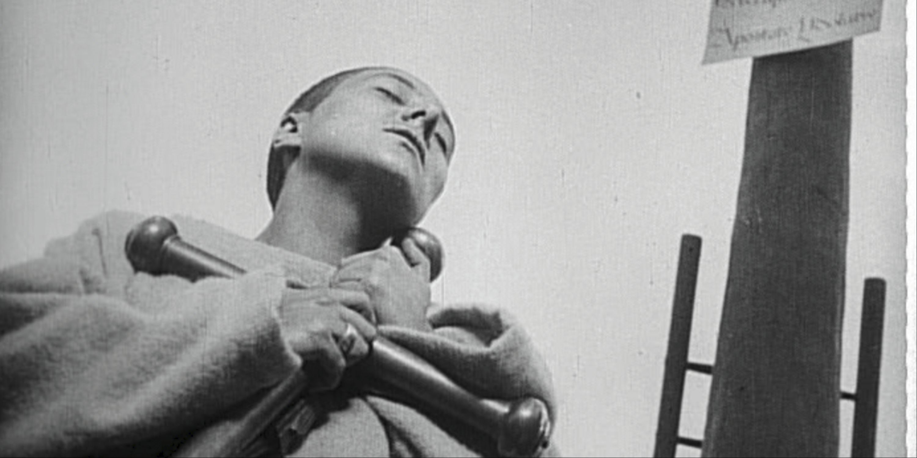 Maria Falconetti holding a cross and praying in The Passion of Joan of Arc