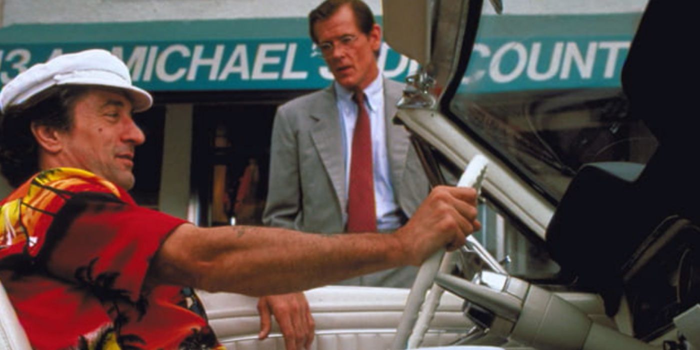 Robert De Niro as Max Cady driving a car while Nick Nolte as Sam Bowden stands on the street in 'Cape Fear'