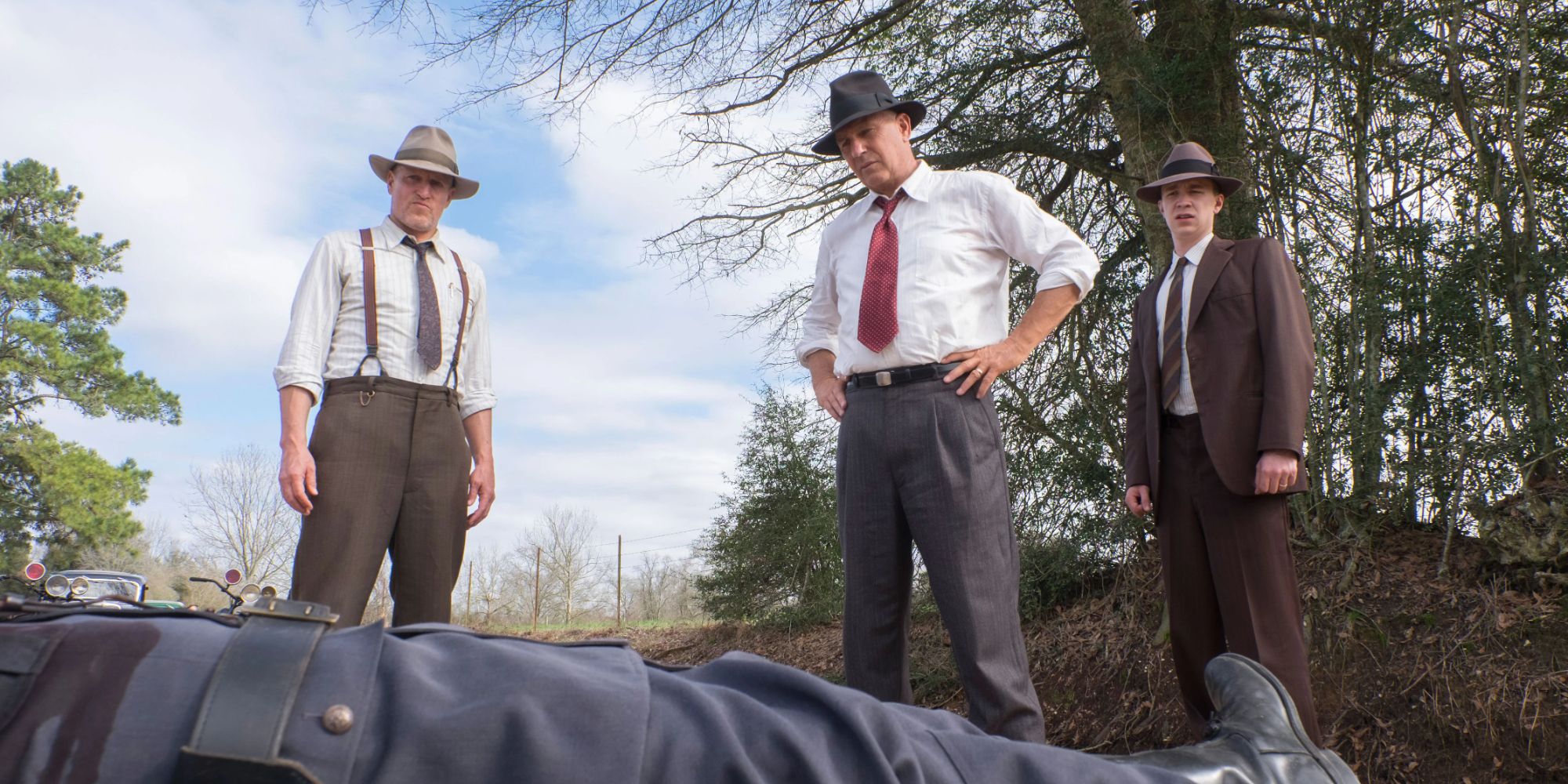 Still of characters looking at a dead body in The Highwaymen