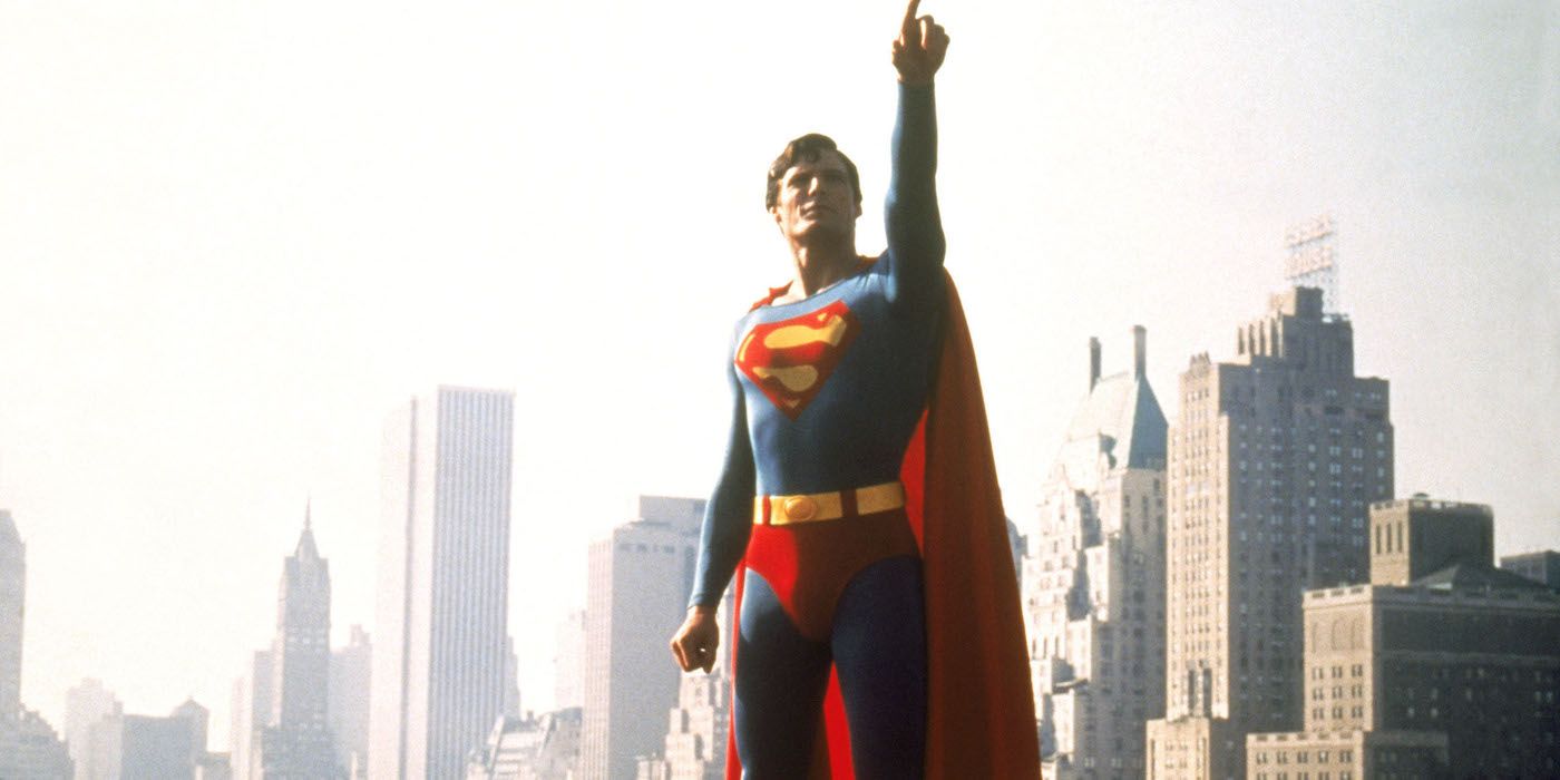 A still from Super/Man: The Christopher Reeve Story where the actor is dressed in costume and pointing towards the sky. 