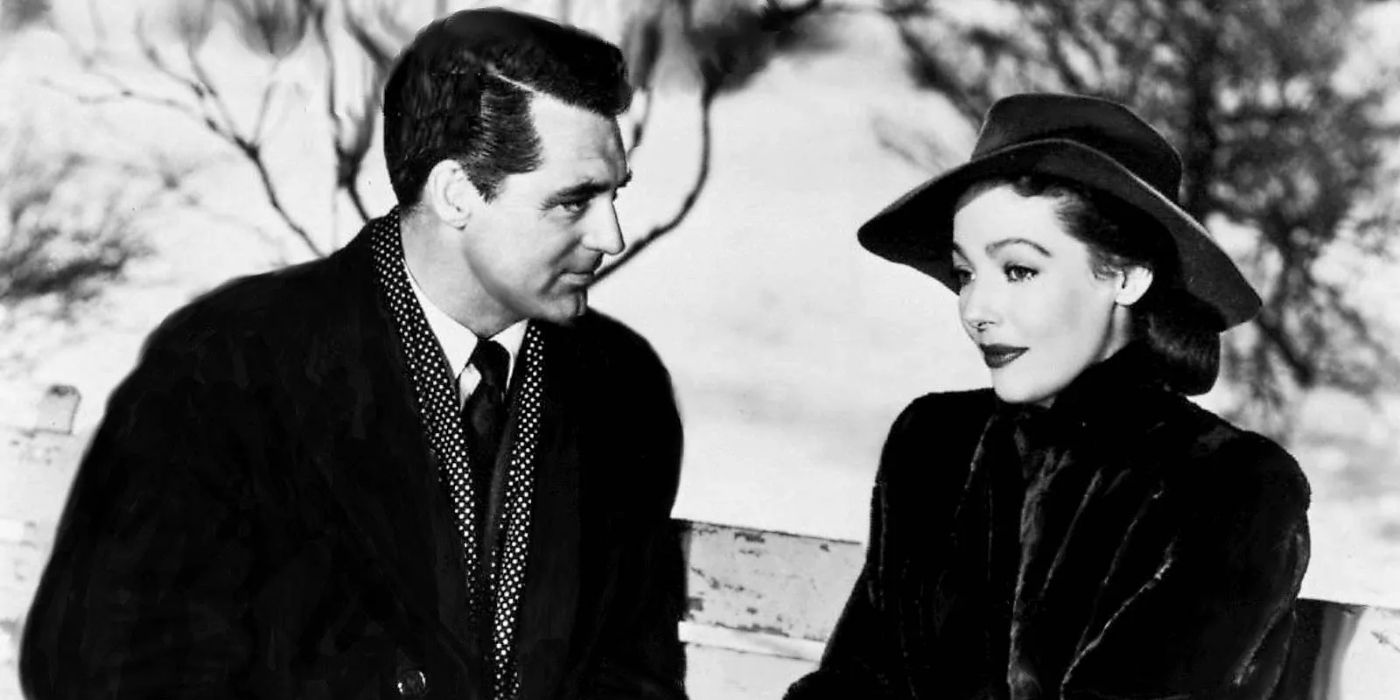 Cary Grant's Dudley sitting next to and staring kindly at Loretta Young's Julia on a park bench in The Bishop's Wife