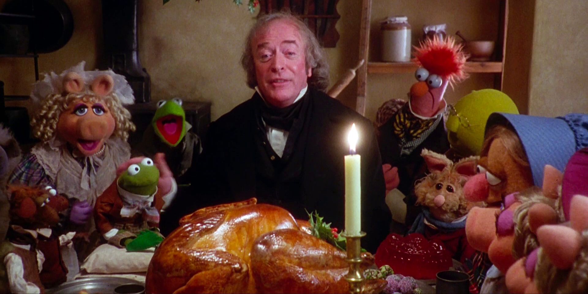 Michael Caine as Ebenezer Scrooge and the Muppets gather around a Christmas dinner in The Muppet Christmas Carol