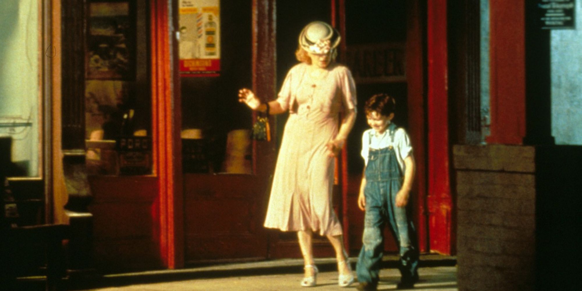 Gena Rowlands as Mae walking down the street with young David in The Neon Bible.
