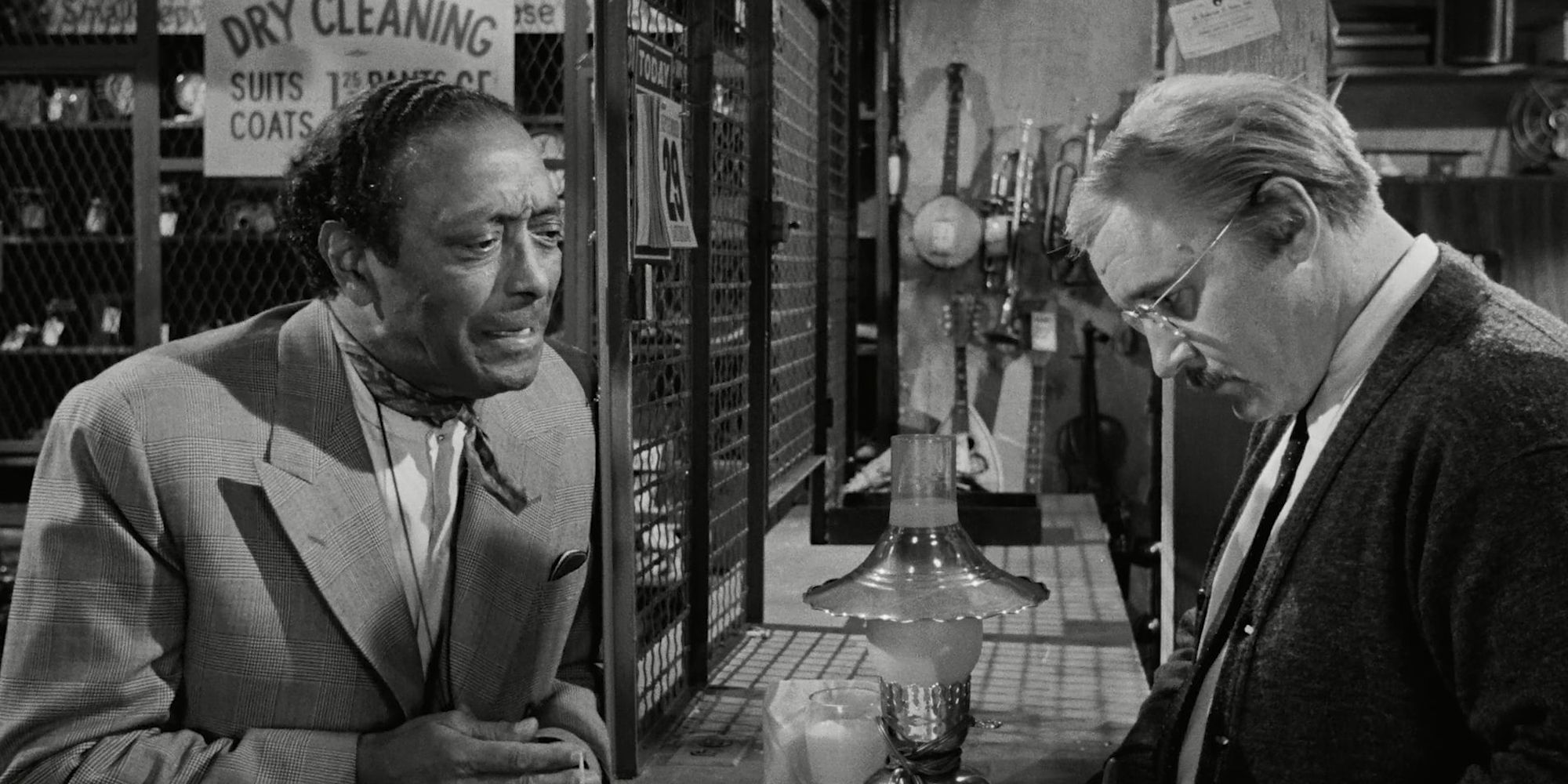 Two men talking over a store counter in the film The Pawnbroker