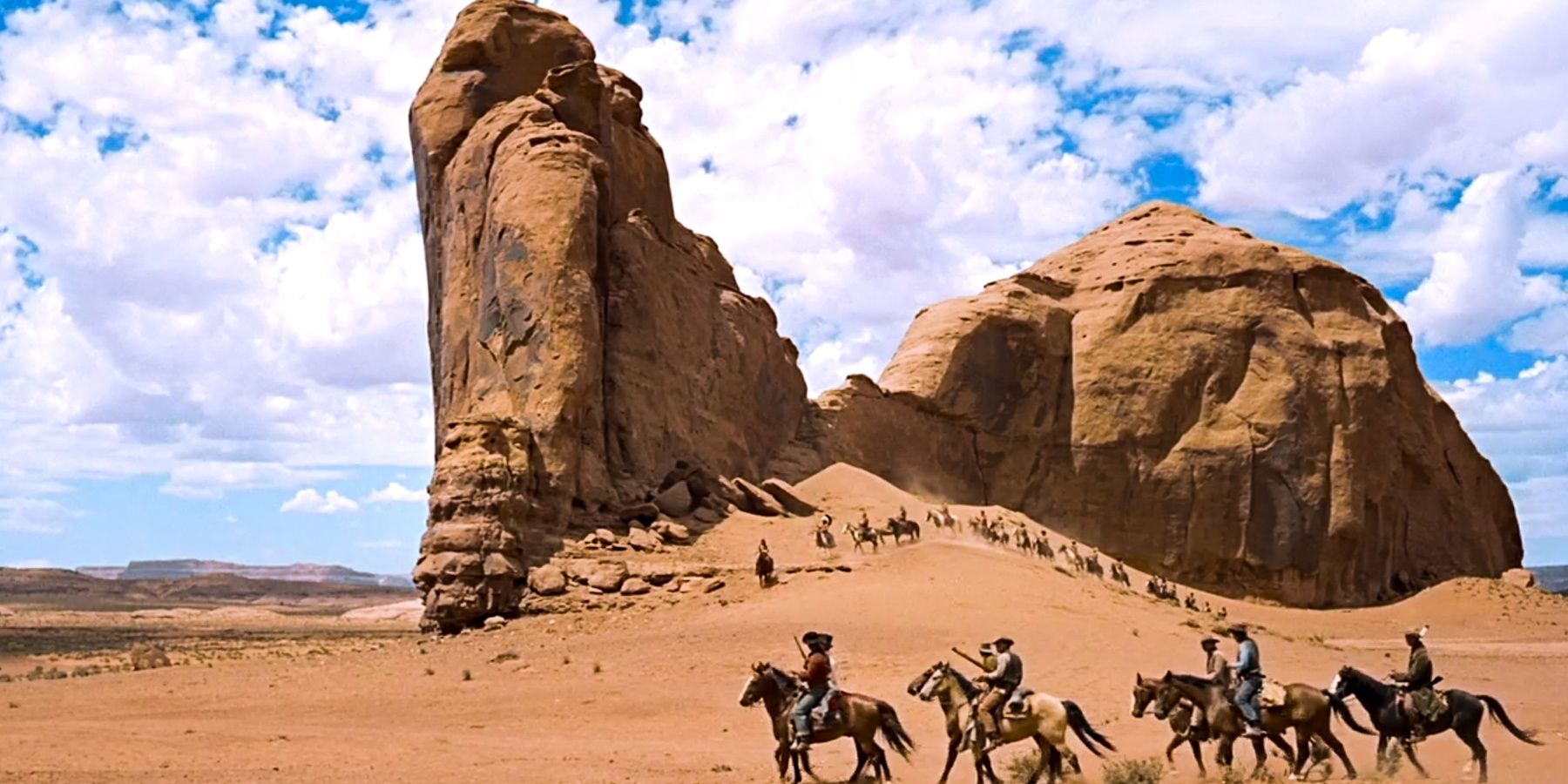 Cowboys riding horses in the desert in John Ford's Western The Searchers