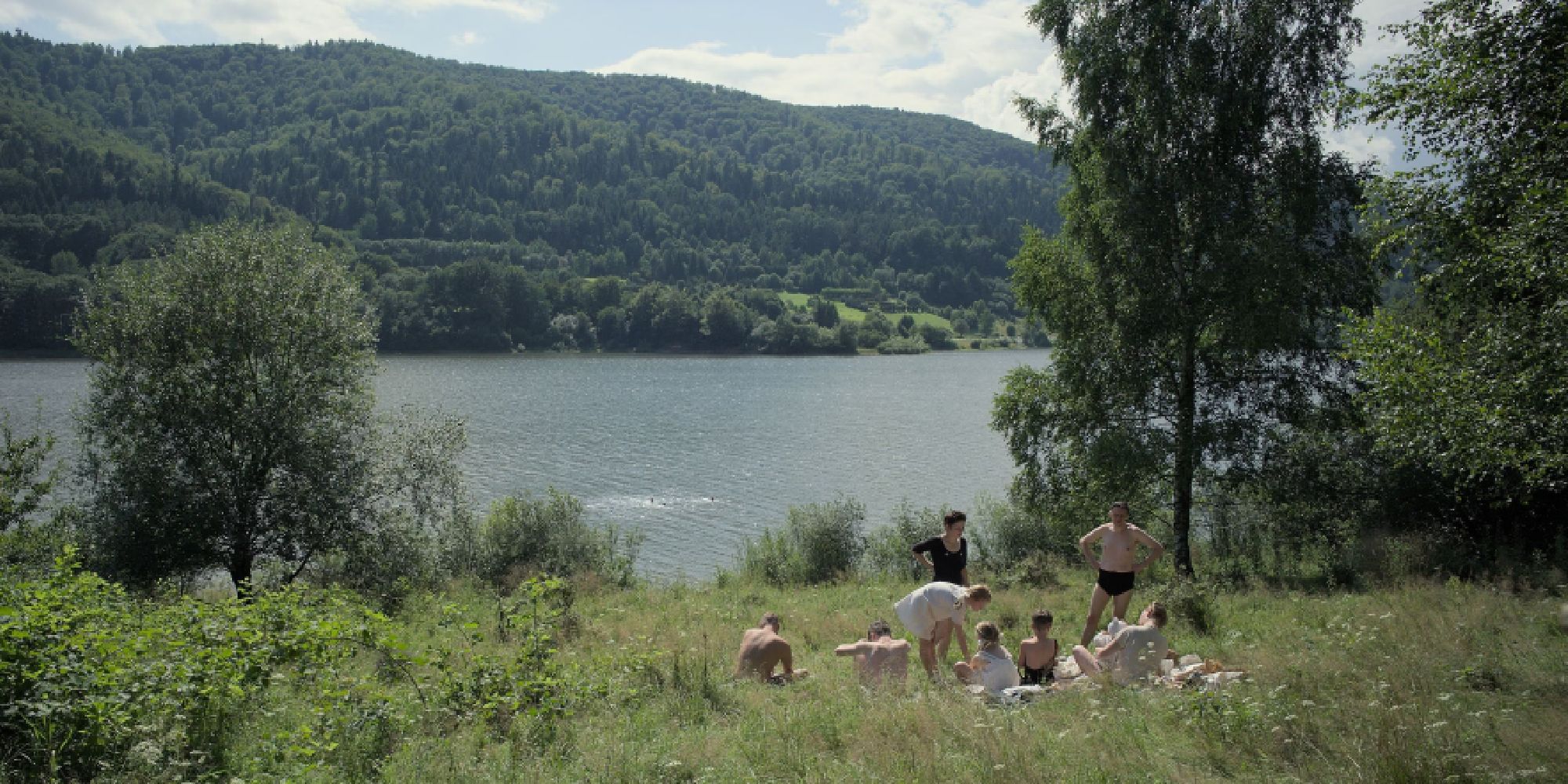 The Höss family sits at the river by their home on a beautiful, sunny day in 'The Zone of Interest'