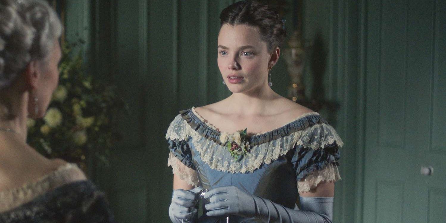 Nan, played by Kristine Froseth, holds a tiara and stares at a character off-camera in The Buccaneers