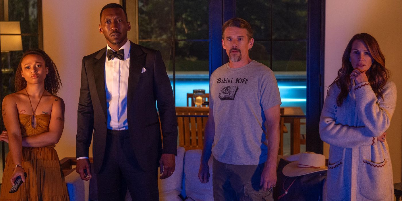 Myha’la, Mahershala Ali, Ethan Hawke, and Julia Roberts as Ruth, George, Clay, and Amanda standing in a line in a house at night looking at something out of frame in Leave the World Behind