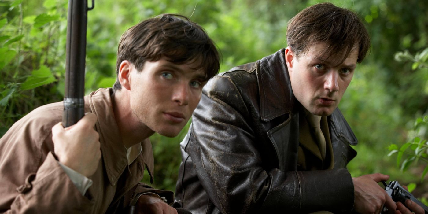 Cillian Murphy as Damien O'Donovan and Padraic Delaney as Teddy O'Donavan crouched down in The Wind That Shakes the Barley