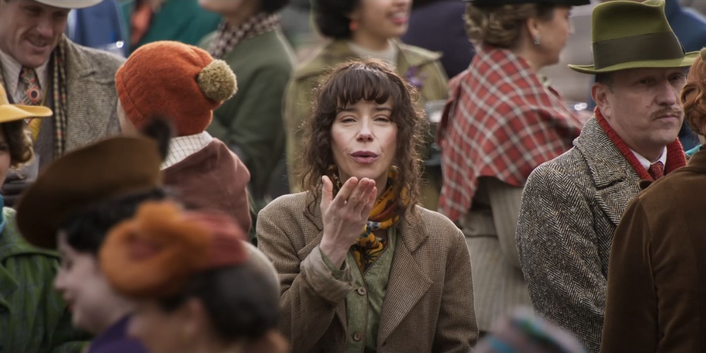 Sally Hawkins as Willy Wonka's mother standing in a crowd, blowing a kiss in Wonka