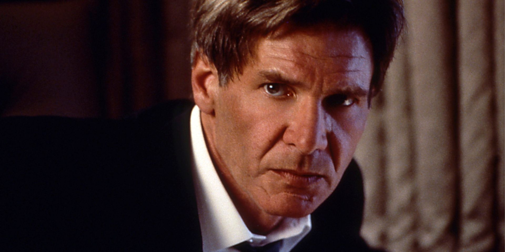 President James Marshall staring sternly ahead in Air Force One.