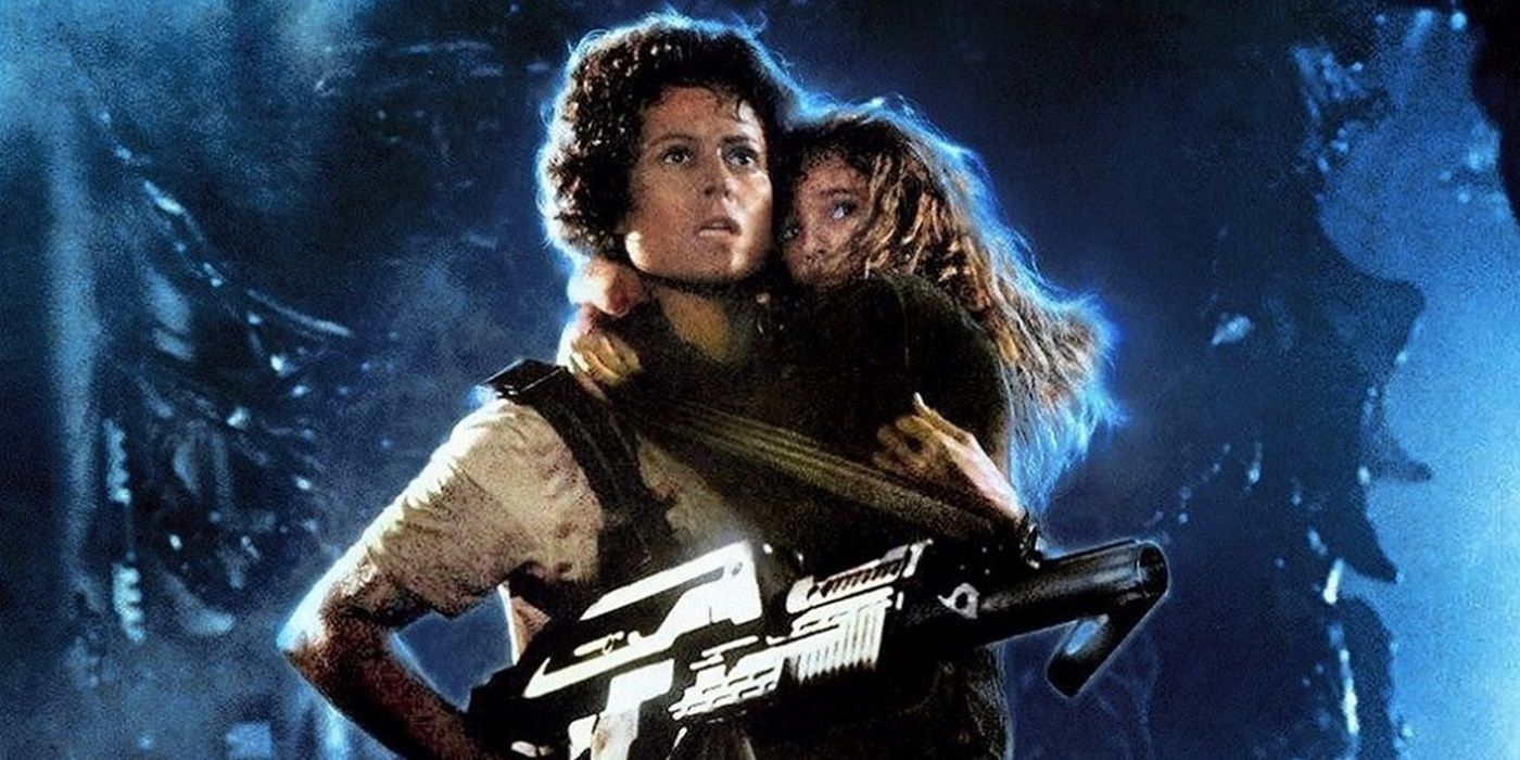 Sigourney Weaver as Ellen Ripley holds Carrie Henn as Newt in one arm and a gun in the other