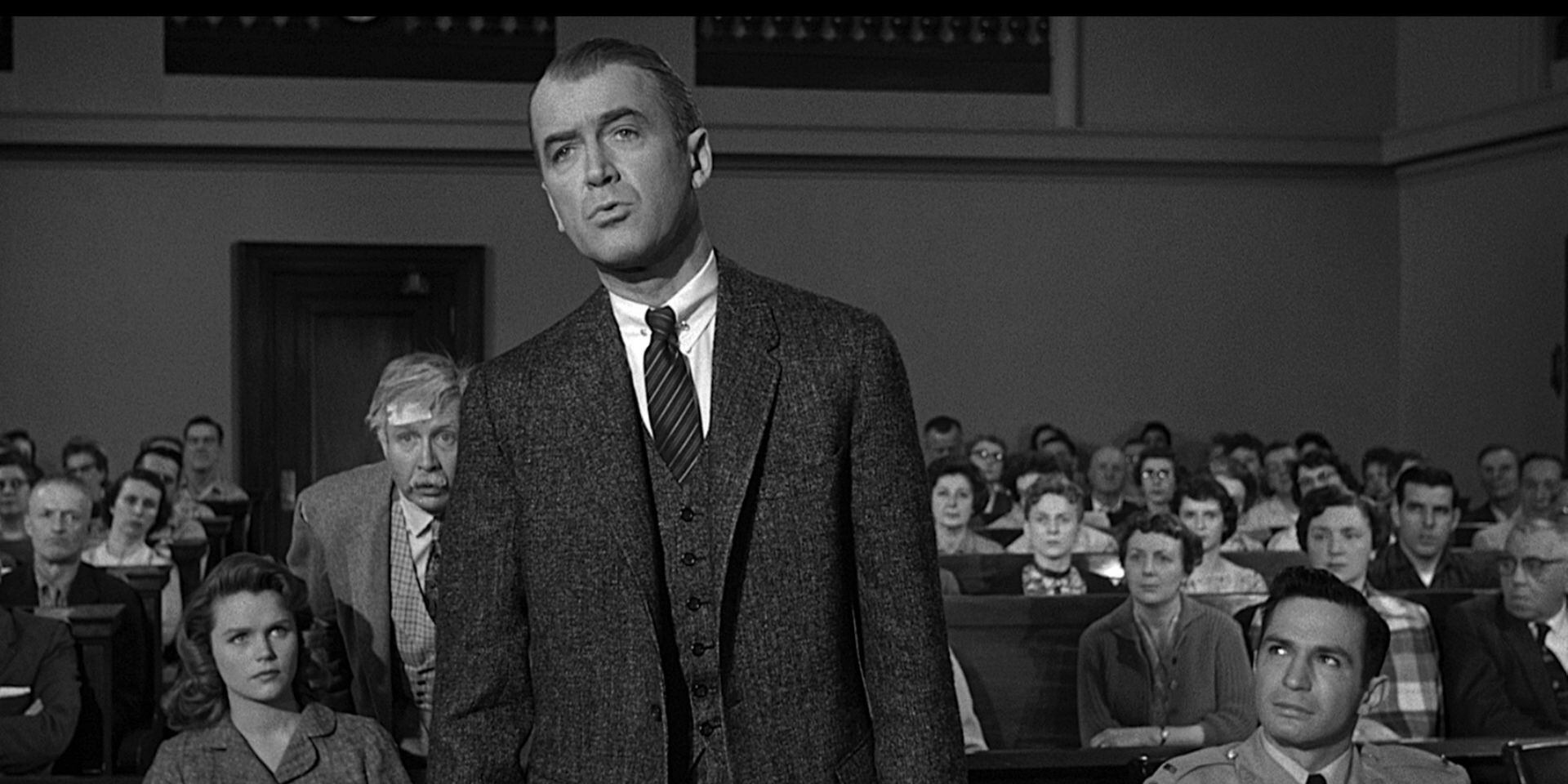 Paul Biegler standing up at his table and speaking in the courtroom in Anatomy of a Murder