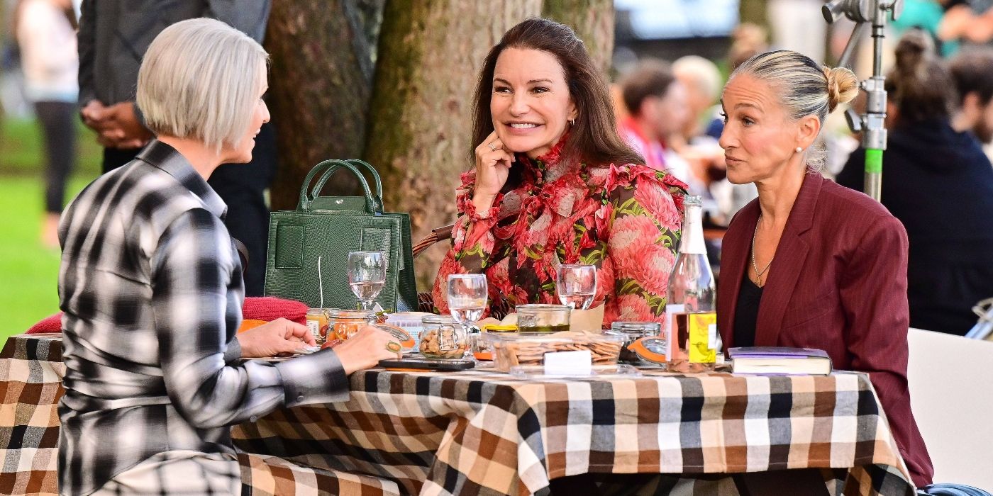 Cynthia Nixon, Kristin Davis, and Sarah Jessica Parker sit at a picnic table in And Just Like That.