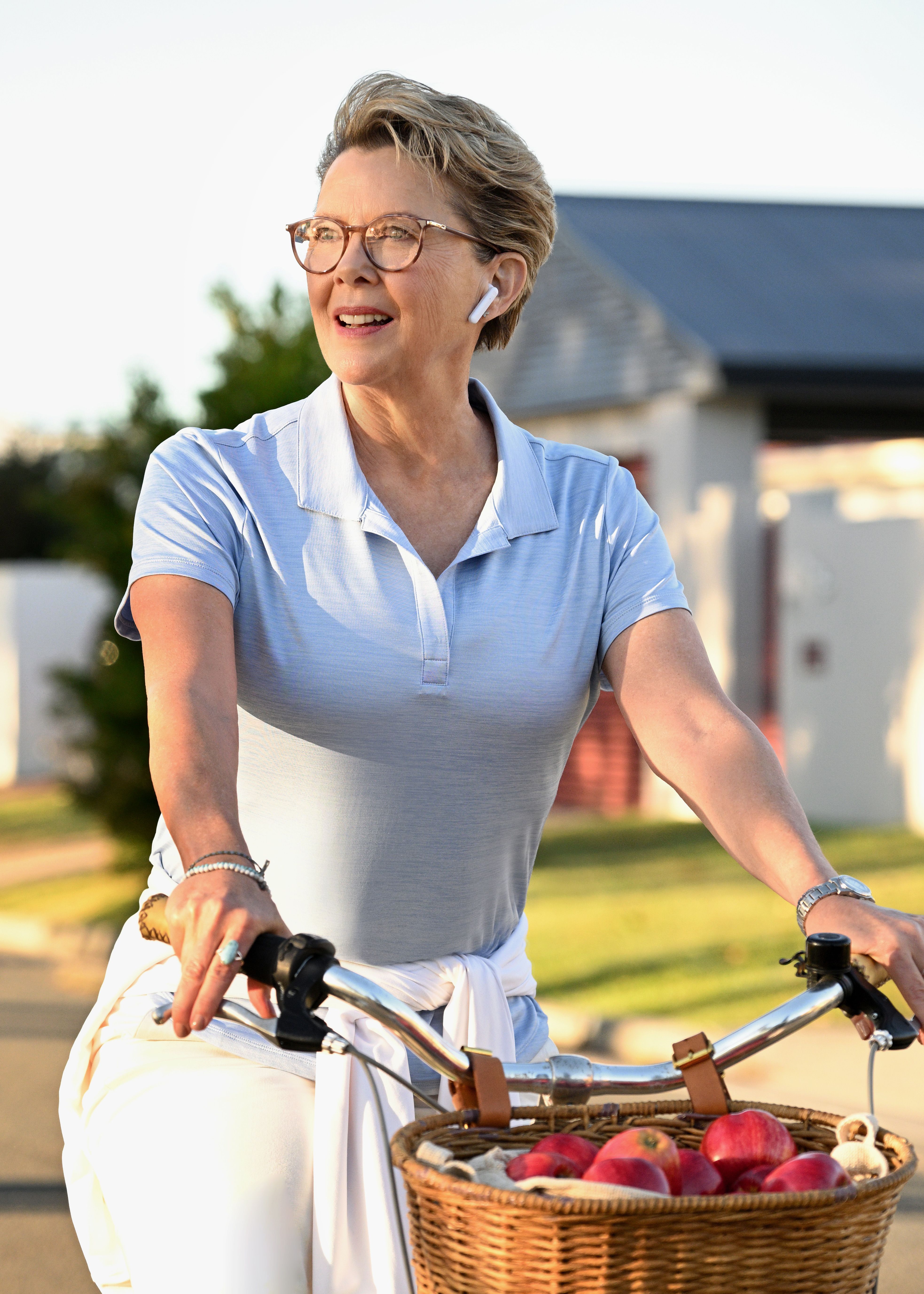 Annette Bening riding a bike through a residential neighborhood in Apples Never Fall