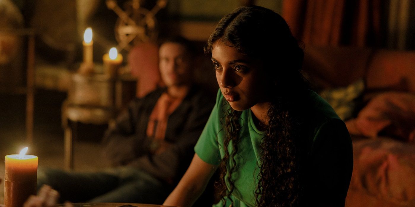 Avantika, staring at a candle, sits in a bedroom with friends in 2024's Tarot