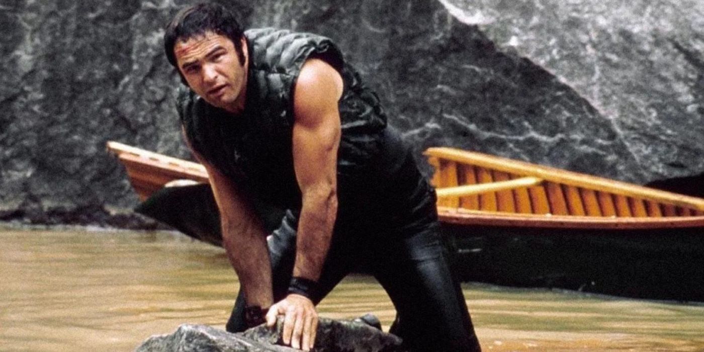 Burt Reynolds stands in a river with large boulders in &lsquo;Deliverance&rsquo;.