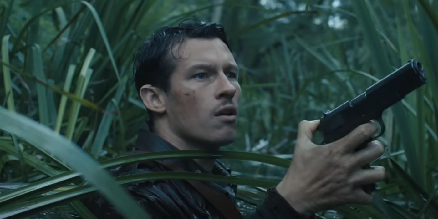 Callum Turner as Major John Egan, holding a pistol in the tall grass, in Masters of the Air