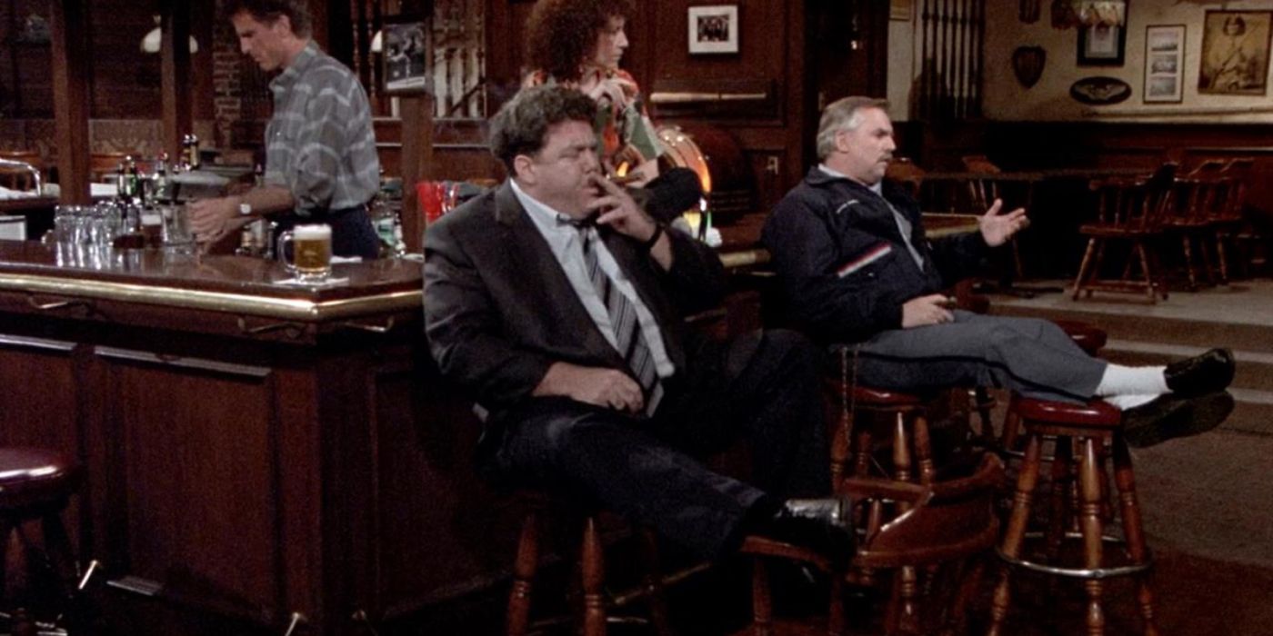 John Ratzenberger and George Wendt smoking cigars and sitting at the bar in Cheers