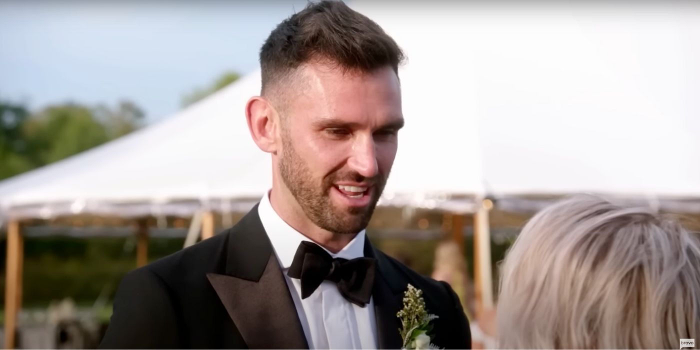 Carl Radke is dressed in a tuxedo and looks into the eyes of a woman with light hair in Summer House.