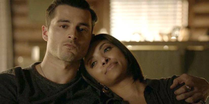 Michael Malarkey sitting down with Kat Graham leaning on his shoulder in The Vampire Diaries.