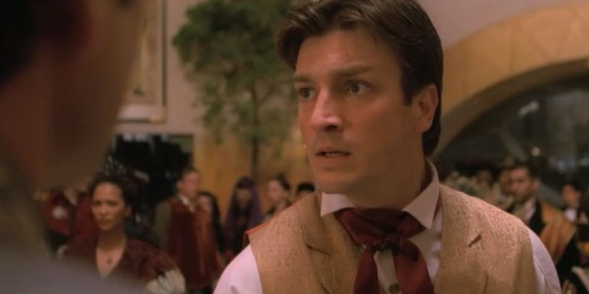 A man at a crowded event looks scared in a scene from Firefly.