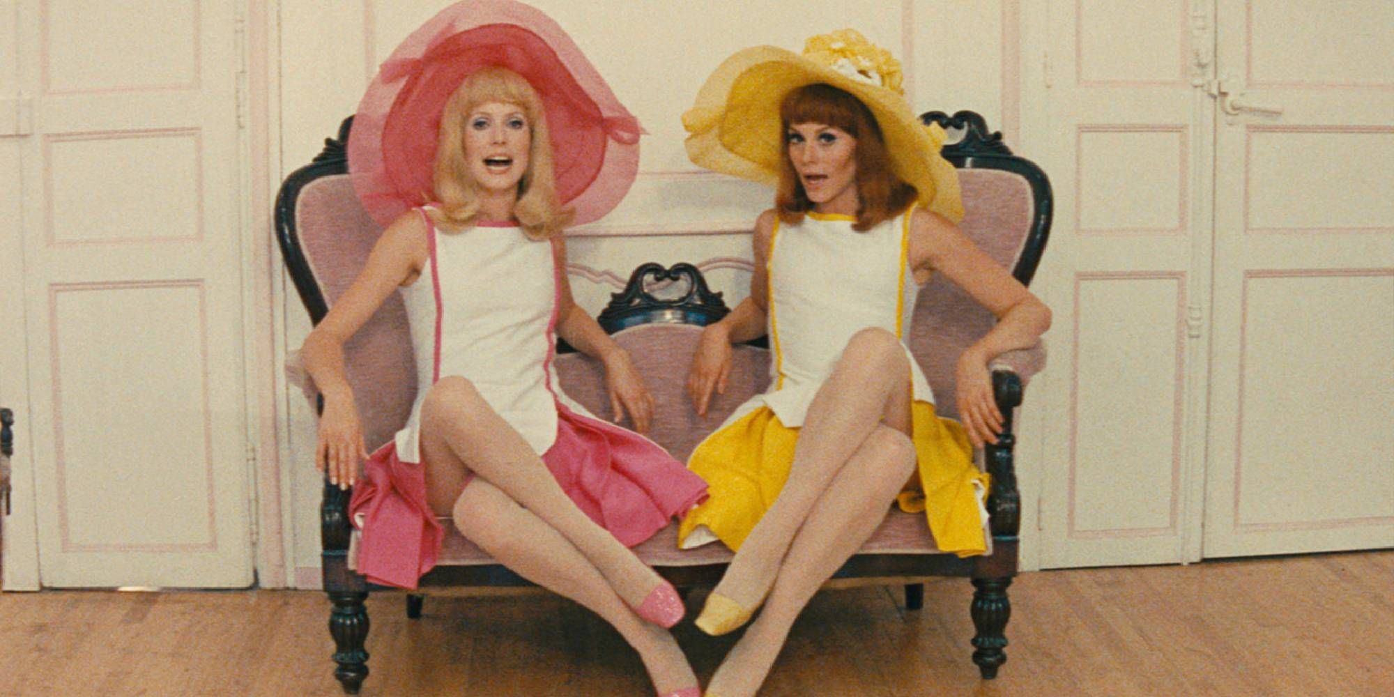 Françoise Dorléac and Catherine Deneuve sitting side by side and singing in Young Girls of Rochefort.