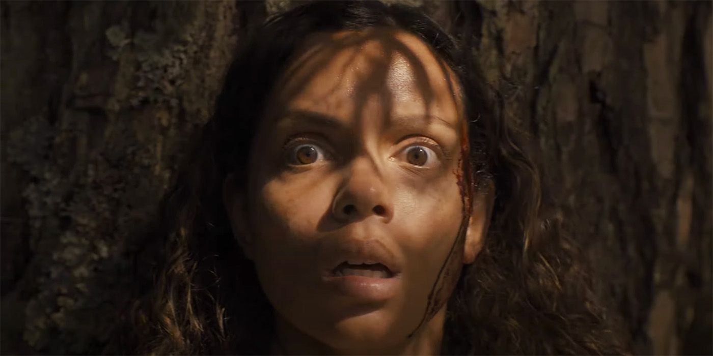 Georgina Campbell as Lennon looking afraid of something in a forest in Lovely, Dark, and Deep