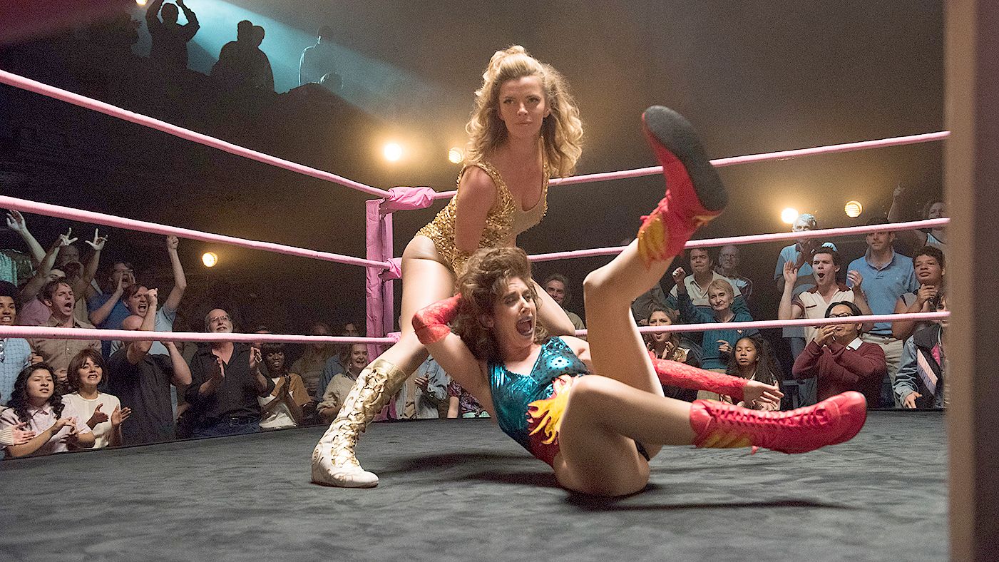 Alison Brie as Ruth and Bettie Gilpin as Debbie wrestling in GLOW