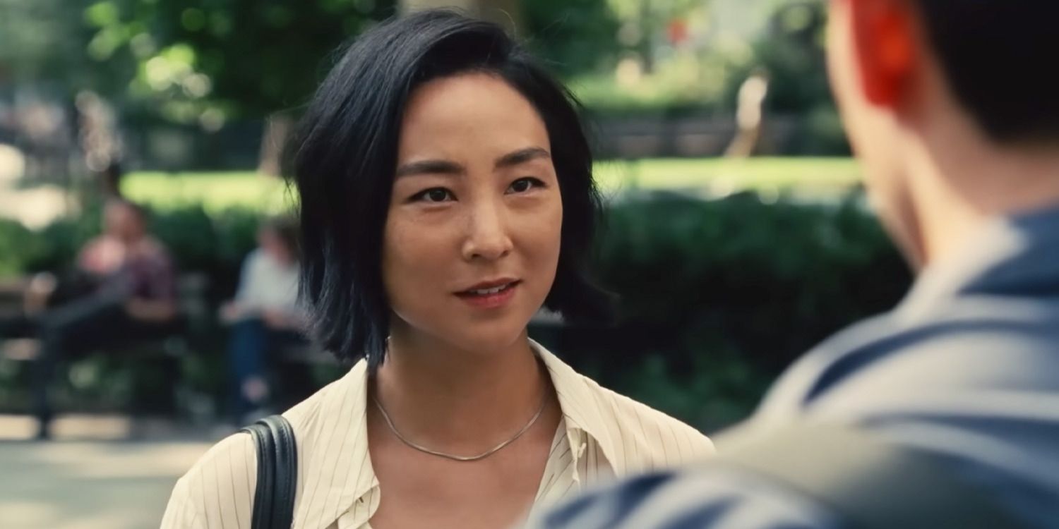 Nora (Greta Lee) stands in a close up shot, looking at Hae Sung (Teo Yoo) in 'Past Lives'