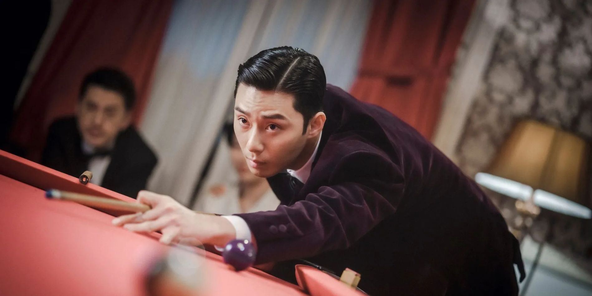Park Seo-jun's Tae-sang leaning over a pool table and aiming the stick in Gyeongseong Creature